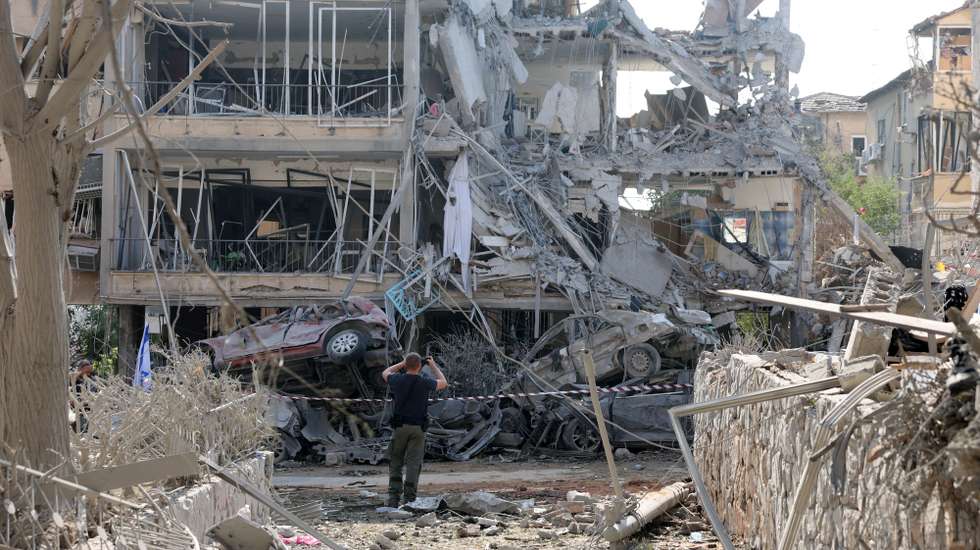 epa12174605 An Israeli police officer inspects a damaged residential building after a ballistic missile strike in Ramat Gan, near Tel Aviv, Israel, 14 June 2025. Israel's military said Iran launched dozens of missiles and drones toward Israel, with some intercepted. Magen David Adom (MDA), Israel's national emergency services, reported at least three killed and dozens of injured, including some in critical condition, in the retaliatory attacks. Israel launched strikes on Iran's nuclear and military facilities on 13 June, targeting top generals and scientists.  EPA/ABIR SULTAN