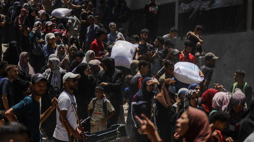 epa12198721 Displaced Palestinians wait to receive aid through the WFP after it successfully arrived at the organization’s warehouses in Gaza City, 26 June 2025. According to the UN half a million people, or one in five people in the Strip are facing starvation while the entire population of the Gaza Strip continues to face a critical risk of famine following 19 months of conflict, mass displacement and severe restrictions on humanitarian aid.  EPA/MOHAMMED SABER