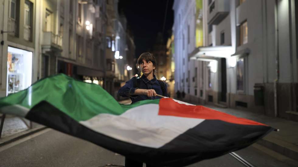 epa12425825 A protester waves a Palestinian flag during a rally in support of the Palestinian people and the Global Sumud Flotilla (GSF) in Porto, Portugal, 02 October 2025. Israeli forces intercepted boats of the Gaza-bound flotilla carrying aid, preventing it from breaching the blockade and reaching the Gaza Strip, according to the Global Sumud Flotilla organizers.  EPA/ESTELA SILVA