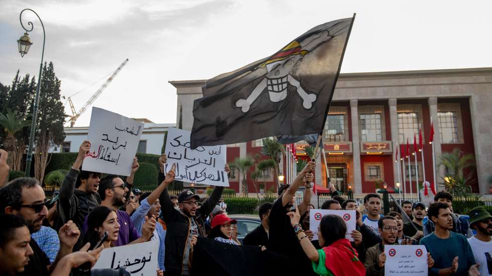 epa12463194 Demonstrators hold up signs and wave a 'Jolly Roger' flag during a protest organized by the self-styled 'GenZ 212' collective in Rabat, Morocco, 18 October 2025. The group protested to demand reforms to public healthcare and education.  EPA/JALAL MORCHIDI