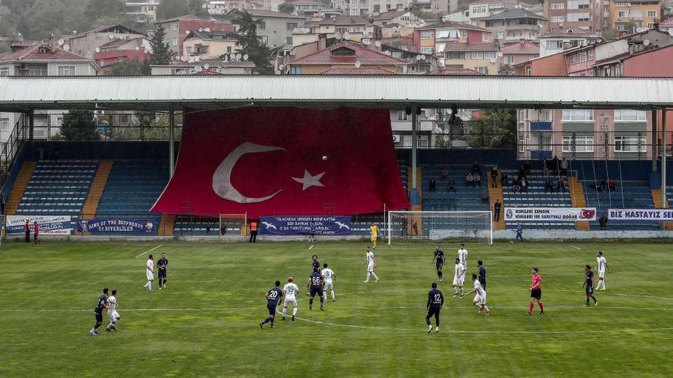 epa08092482 Players in action during the soccer match between Sarıyerspor and Amedspor as a huge Turkish flag is hanged on the empty Amedspor's fans grandstand due to a ban for 76 away mathes for supporters, in Istanbul, Turkey, 05 October 2019 (issued 28 December 2019). Amedspor is a sports club from the Kurdish-majority city of Diyarbaki in south-eastern Turkey playing in the Turkish Football Federation Second League (TFF 2. Lig). The club was founded in 1990 and in 2014 they changed their name to Amedspor without official approval and hence fined by the TFF.  EPA/SEDAT SUNA  ATTENTION: This Image is part of a PHOTO SET