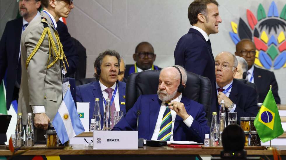 epa12541330 France's President Emmanuel Macron walks behind Brazil's President Luiz Inacio Lula da Silva as they attend a plenary session on the opening day of the G20 Summit at the Nasrec Expo Centre in Johannesburg, South Africa, 22 November 2025. World leaders are gathering in South Africa, the host of this year's G20 Leaders' Summit on 22 and 23 November 2025, to discuss the global economy, development and financing.  EPA/THOMAS MUKOYA / POOL