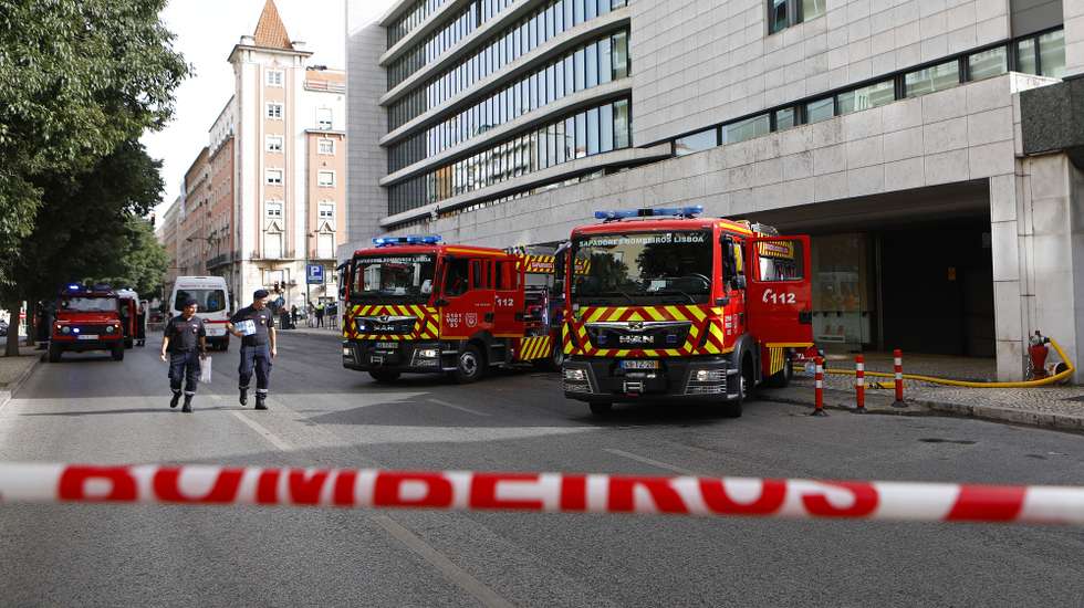 Elementos dos Bombeiros Sapadores de Lisboa, caminham junto a um prédio contíguo ao El Corte Inglês, onde deflagrou um incêndio no piso -3, envolvendo um motociclo e um automóvel, levando ao corte de trânsito na Avenida António Augusto Aguiar, em Lisboa, 5 de agosto de 2018. O prédio foi evacuado por segurança e a circulação automóvel foi cortada junto ao local, adiantaram os Sapadores no local. Segundo outra fonte do Regimento de Sapadores de Bombeiros de Lisboa às 16:50 estavam no local 30 homens com oito viaturas. ANTÓNIO PEDRO SANTOS/LUSA