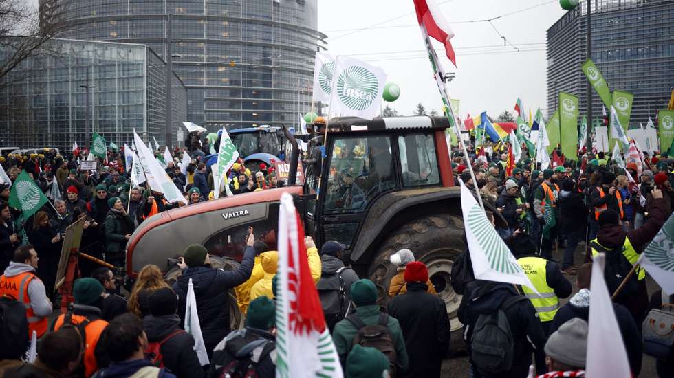 epa12663769 European farmers hold flags as they protest in front of the European Parliament in Strasbourg, France, 20 January 2026. The protest, called by unions against the EU-Mercosur trade deal, drew thousands of farmers from France and other European countries, along with more than 700 tractors.  EPA/YOAN VALAT