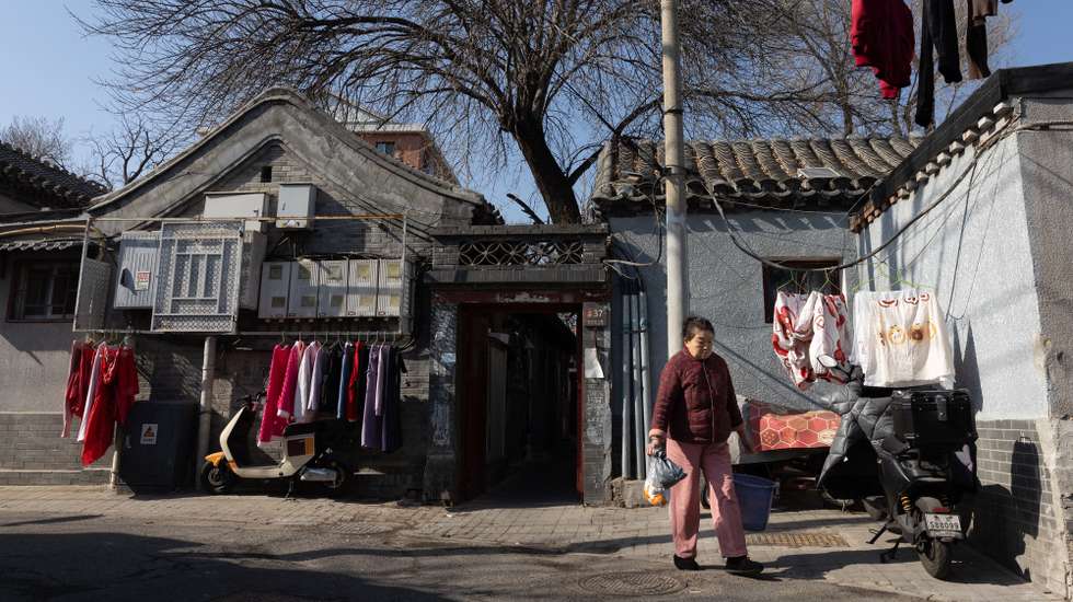 epa12733069 A person walks past an entrance to courtyard homes through a hutong in Beijing, China, 13 February 2026. According to the National Bureau of Statistics (NBS), China's new home prices in 70 cities decreased 3.1 percent year-on-year in January, further falling from the 2.7 percent drop recorded in the previous month.  EPA/JESSICA LEE