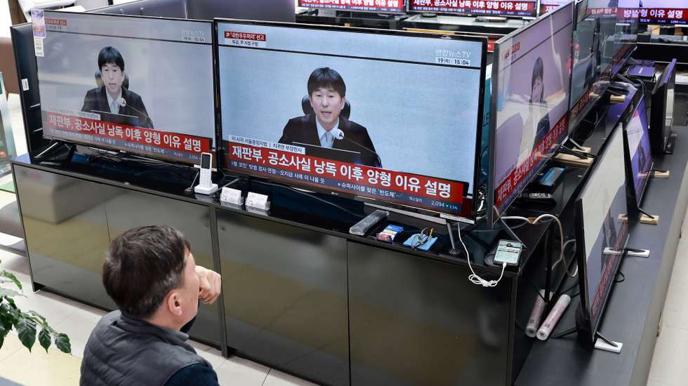 epa12756223 Televisions at a home appliance shop in Seoul, South Korea, 19 February 2026, show a live broadcast of a court hearing that jailed former President Yoon Suk Yeol attended to receive the first verdict on whether his 2024 imposition of martial law constituted an insurrection following special prosecutors' recommendation of the death penalty.  EPA/YONHAP SOUTH KOREA OUT