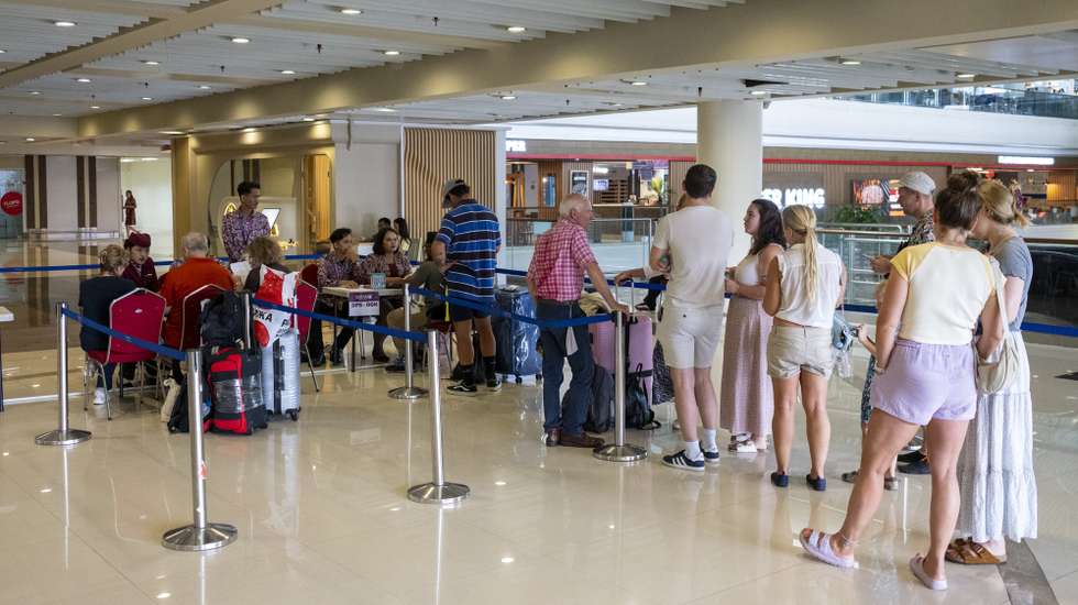 epa12786262 Passengers queue for assistance from Qatar Airways staff after their flight was canceled at Ngurah Rai International Airport in Bali, Indonesia, 01 March 2026. At least four flights from Bali to Doha and Dubai have been canceled amid US and Israeli strikes on Iran.  EPA/MADE NAGI