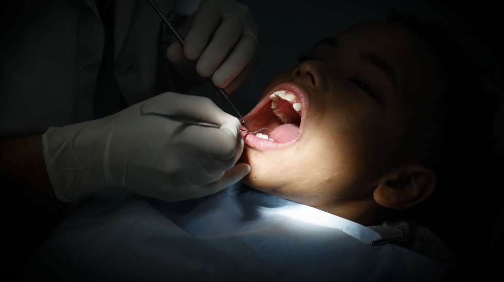 Uma dentista durante um tratamento a um rapaz na clínica “O Sol” que oferece tratamento dentário gratuito a crianças até aos 18 anos, Lisboa, 19 de março de 2025. A 20 de Março comemora-se o Dia Mundial da Saúde Oral.  (ACOMPANHA TEXTO DE 20-03-2025) ANTÓNIO PEDRO SANTOS/LUSA