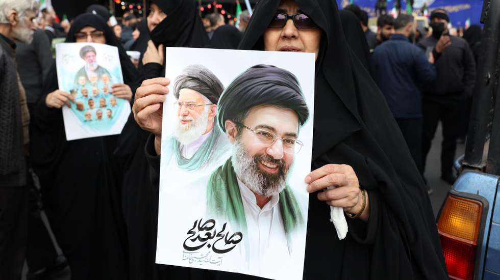 epa12811438 Iranians hold posters of the new Iranian supreme leader Ayatollah Mojtaba Khamenei during a mass funeral for the Iran's Revolutionary Guards Corps (IRGC) commanders, army commanders and other victims who were killed during the Iran-US and Israel war in Tehran, Iran, 11 March 2026. A joint Israeli and US military operation continues to target multiple locations across Iran since the early hours of 28 February 2026.  EPA/ABEDIN TAHERKENAREH