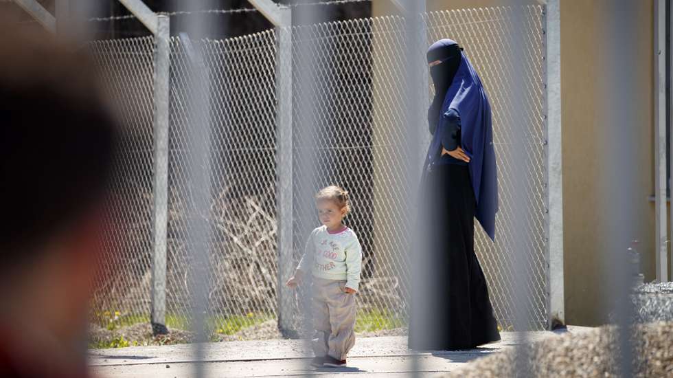 epa07521566 A Kosovar woman and a child walk inside the compound of the foreign detention center in the village of Vranidoll, Kosovo, 22 April 2019. Several  Kosovo women who were returned from Syria on 20 April are accused for being part of terrorist groups and were questioned by Kosovo prosecutors and police. Kosovo authorities repatriated 110 of its citizens from Syria, mostly mothers with their children who accompanied their partners to join jihadist groups in the war-torn country.  EPA/VALDRIN XHEMAJ