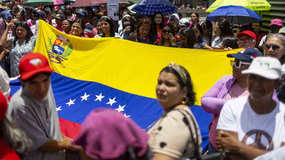 epa12903497 Women hold a Venezuelan flag during a demonstration in Caracas, Venezuela, 20 April 2026. Hundreds of pro Chavez women protested against racist comments directed at acting President Delcy Rodriguez after she was referred to as the monkey at an opposition rally in Madrid, and said they are collecting signatures to file a complaint with the Spanish Embassy in Venezuela.  EPA/Miguel Gutiérrez