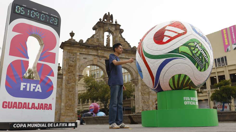 epa12915420 A person poses for a photo next to a giant soccer ball in Guadalajara, Mexico, 25 April 2026 (issued 26 April 2026). Some hundred giant soccer ball sculptures have been placed in Guadalajara in the run-up to the FIFA World Cup 2026.  EPA/Francisco Guasco