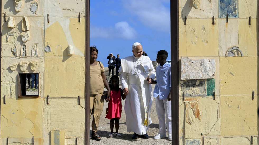epa13085281 A handout picture provided by the Vatican Media shows Pope Leo XIV (C) praying during his stop at the Gate of Europe (Porta d'Europa) monument as part of his pastoral visit to the island of Lampedusa, in southern Italy, 04 July 2026.  EPA/VATICAN MEDIA HANDOUT HANDOUT EDITORIAL USE ONLY/NO SALES