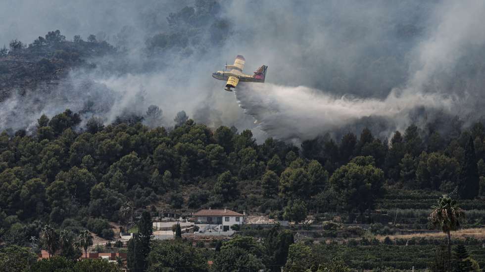 epa13133816 A hidroplane sprays water to extinguish a fire set in Betxi, Castellon, Spain, 26 July 2026. The fires in the area have forced the evacuation of more than 16.000 persons.  EPA/Manuel Bruque