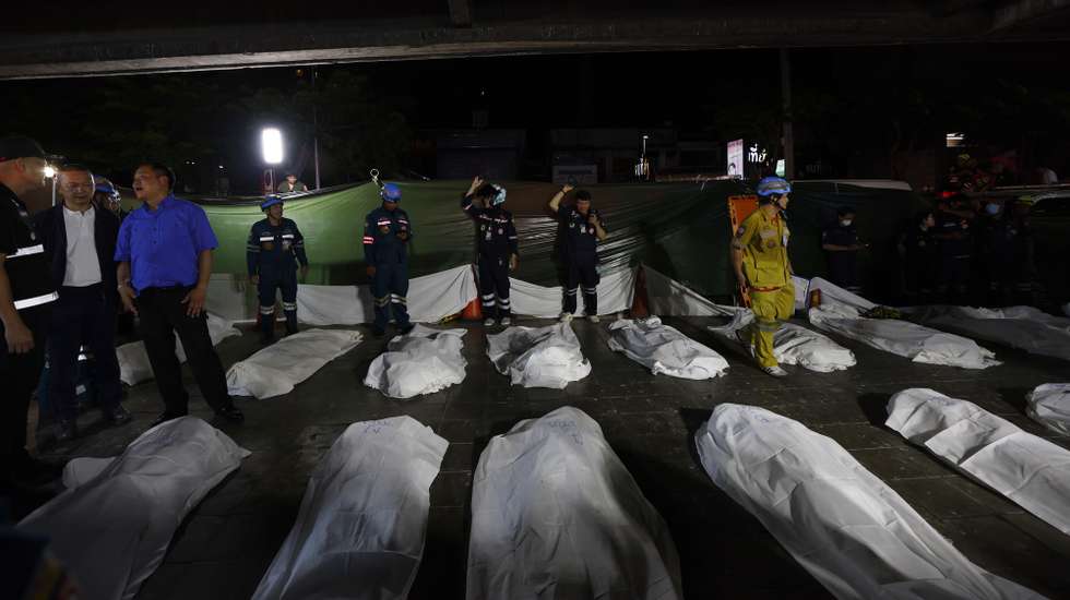 epa13107675 Thai Prime Minister Anutin Charnvirakul (3-L) inspects the situation next to fire victims' bodies outside the burned pub in Bangkok, Thailand, early on 13 July 2026. At least 27 people were killed after a fire engulfed the bar, according to Anutin.  EPA/RUNGROJ YONGRIT
