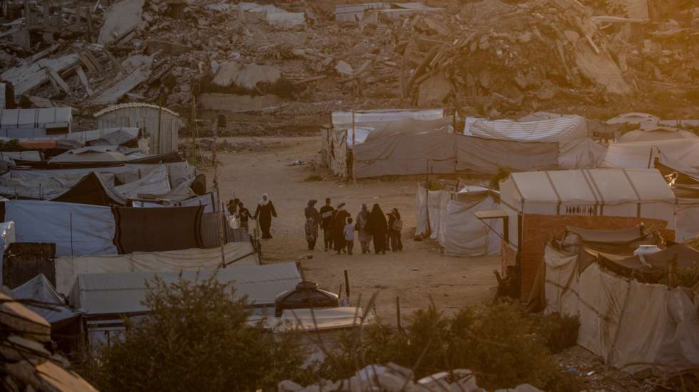 epa13156118 Displaced Palestinians walk between destroyed houses in Jabaliya, northern Gaza City, 07 August 2026. Around 1.9 million people in Gaza, nearly 90 percent of the population, have been displaced since the Israel-Hamas conflict began in October 2023, according to the United Nations.  EPA/MOHAMMED SABER