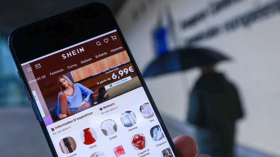 epa12749291 The Shein website is displayed on a smartphone in front of the European Commission headquarters in Brussels, Belgium, 17 February 2026. The European Commission is expected to provide a formal update on its investigation into Shein under the Digital Services Act (DSA).  EPA/Olivier Hoslet
