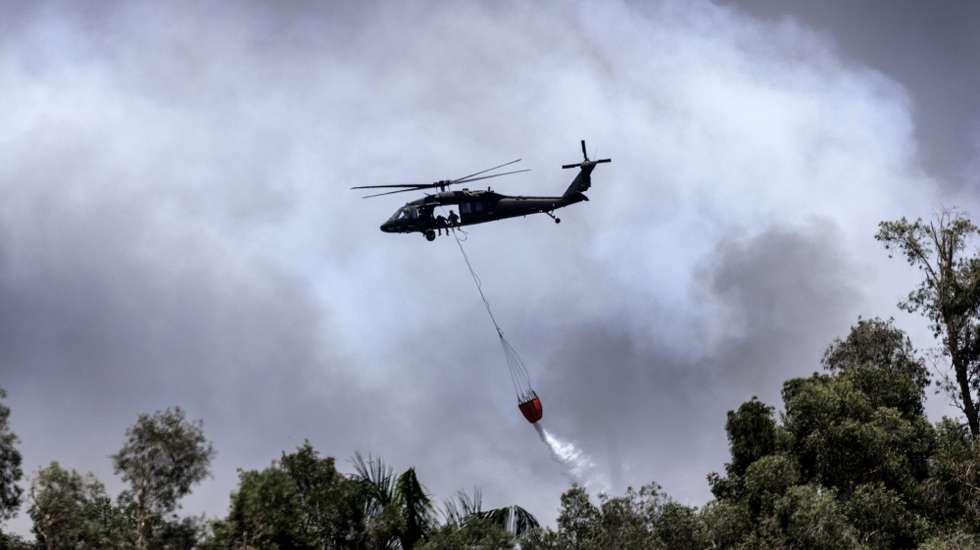 epaselect epa13050469 A helicopter conducts water drops over an active wildfire in the Everglades as fires continue to burn west of Miami, Florida, USA, 19 June 2026. Wildfires in the Everglades have scorched thousands of acres, blanketing parts of South Florida with smoke and causing road closures as firefighters continue containment efforts. Officials believe a lightning strike may have ignited the fire, with severe drought conditions contributing to its rapid spread.  EPA/CRISTOBAL HERRERA-ULASHKEVICH