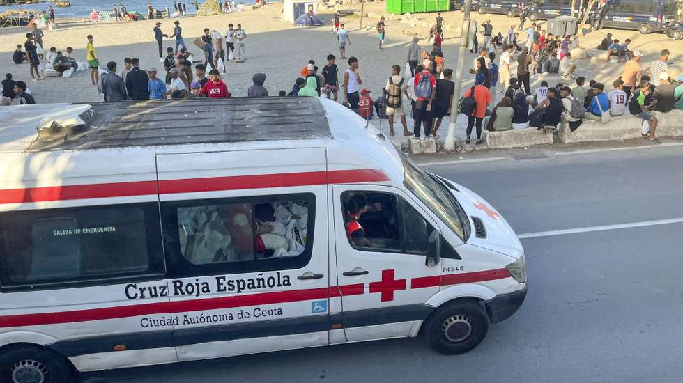 epa13195373 Red Cross members distribute food to migrants at El Trampolin beach in Ceuta, 27 August 2026. Protests erupted in the Spanish enclave of Ceuta over the past two days, with residents demanding political resignations and the expulsion of migrants amid an escalating migration crisis.  EPA/REDUAN