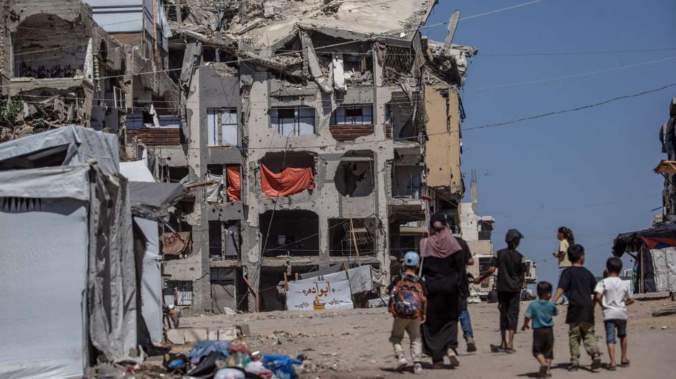epaselect epa13252370 Displaced Palestinians walk near ruined residential buildings in northern Gaza City, Gaza Strip, 20 September 2026. The UN warned that hundreds of war-damaged structures across Gaza remain at risk of collapse while sheltering displaced families amid acute shelter shortages.  EPA/MOHAMMED SABER