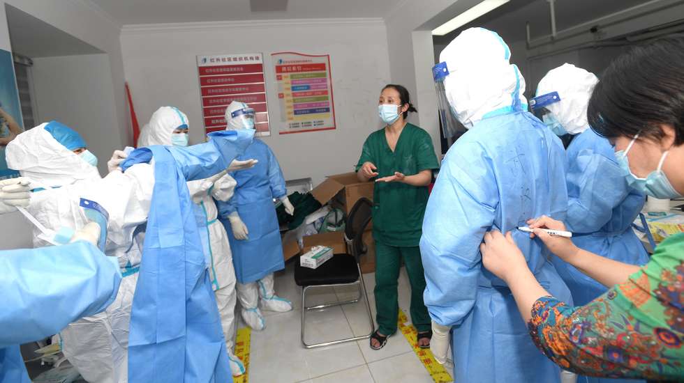 epa09392200 Medical workers prepare to take swab samples for the mass Covid-19 test in a residential block in Wuhan, Hubei province, China, 03 August 2021. Wuhan, the epicenter of the coronavirus outbreak, is testing all of its eleven million residents for the Sars-CoV-2 coronavirus after seven new infections were registered, a city official said as quoted by several media.  EPA/SHEPHERD ZHOU CHINA OUT