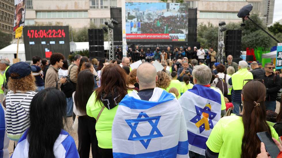epa11851113 People watch a live stream on a big screen reporting on the release of four Israeli female soldier hostages, who are being transferred from Hamas to the Red Cross, in hostages square outside the Kirya military base in Tel Aviv, Israel, 25 January 2025. The four soldiers, Liri Albag, Naama Levy, Karina Ariev, and Daniella Gilboa, were taken hostage from an intelligence outpost near the Israeli Gaza border during the Hamas-led attack on 07 October 2023. Israel and Hamas implemented the first phase of a hostage release and ceasefire deal on 19 January 2025.  EPA/ABIR SULTAN