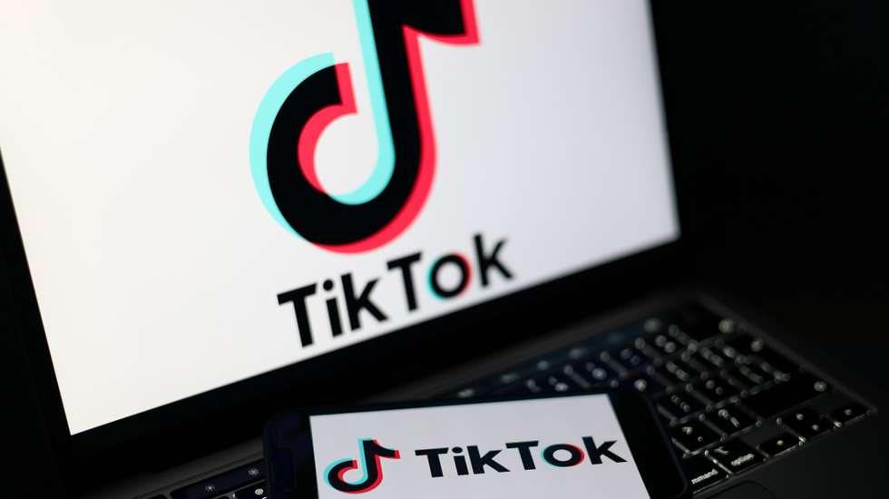 epa12674797 The TikTok logo displayed on a mobile phone and on a laptop screen in Liverpool, Britain, 23 January 2026. A proposal to ban under-16s from accessing social media in the UK will be considered in the House of Commons after peers in the House of Lords voted 261 to 150 in favour of an amendment to the Children’s Wellbeing and Schools Bill. If adopted, the amendment would require social media companies to implement strict and effective age checks in order to prevent underage users from signing up.  EPA/ADAM VAUGHAN