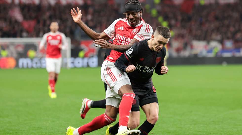 epa12812514 Noni Madueke of Arsenal (L) in action against Alejandro Grimaldo of Bayer Leverkusen (R) during the UEFA Champions League Round of 16 1st leg match Bayer 04 Leverkusen against Arsenal FC, in Leverkusen, Germany, 11 March 2026.  EPA/CHRISTOPHER NEUNDORF