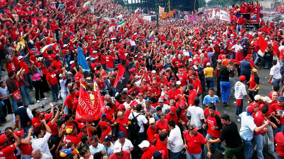 epa00807035 Supporters of Venezuelan President Hugo Chavez (arriving in a bus on the top-right) greet their leader on Friday, 01 September 2006 in Caracas, Venezuela. This was the first big electoral campaign event organized. Chaves is seeking re-election in the December elections.  EPA/Chico Sanchez