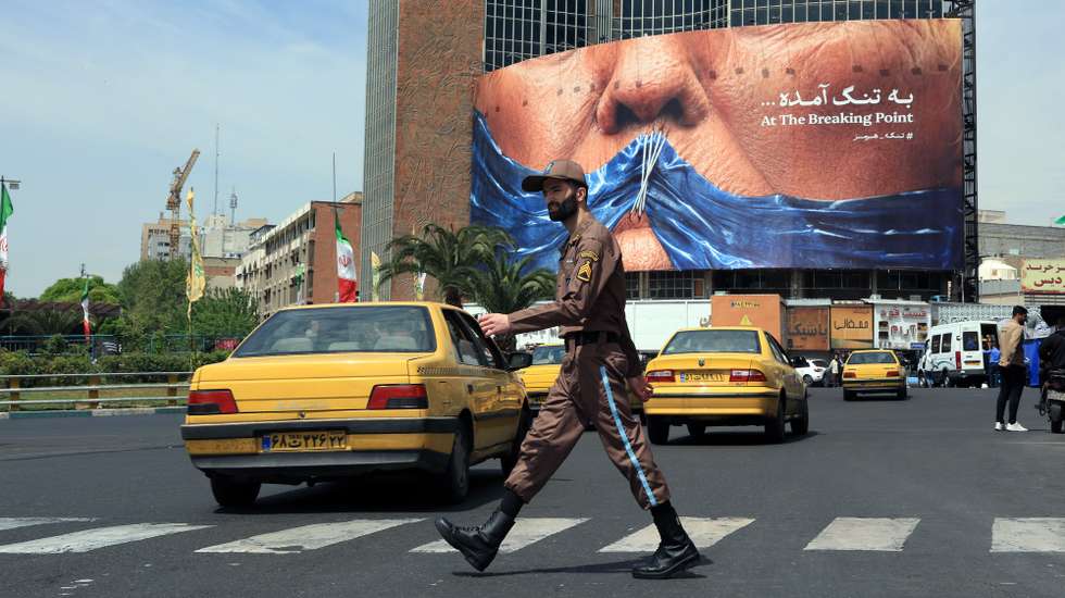 epa12927595 An Iranian soldier walk past a huge anti-US billboard referring to US president Donald Trump and Strait of Hormuz at Valiasr square in Tehran, Iran, 02 May 2026. The conflict between Iran and the United States over the Strait of Hormuz continues, as the ceasefire between the two countries has been extended indefinitely and diplomatic negotiations are ongoing.  EPA/ABEDIN TAHERKENAREH