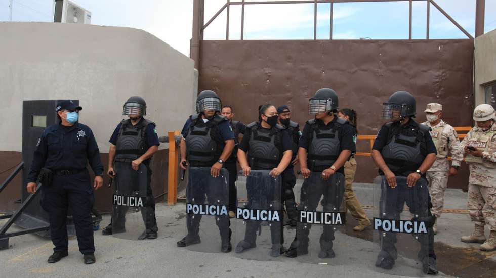 epa10116686 Members of the riot police guard outside the Social Reintegration Center (Cereso) number 3, in Juarez City, state of Chihuahua, Mexico, 11 August 2022. At least three people died and several were injured after a fight inside a prison, with high rates of violence, the Chihuahua State Attorney General's Office (FGE) reported.  EPA/Luis Torres