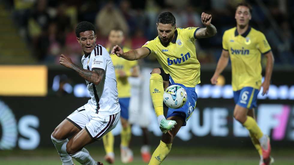 O jogador do Arouca, Javier Felipe (C), disputa a bola com o jogador do Estrela Amadora, Antonetti (E), durante o jogo da I Liga de futebol realizado no Estádio Municipal de Arouca, em Arouca, 11 de outubro de 2026. MANUEL FERNANDO ARAÚJO/LUSA