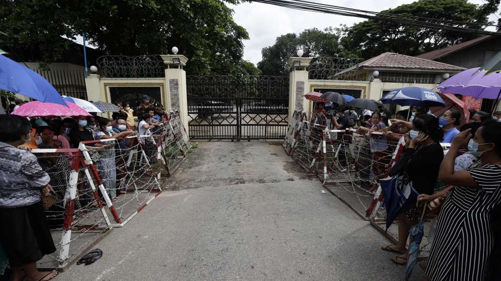 epa09312589 People wait behind barricades for their relatives to be released outside the main entrance of Insein prison compound in Yangon, Myanmar, 30 June 2021. The prison authority confirmed the upcoming release of about 700 prisoners from Yangon's Insein jail, including some who were jailed for opposing the military. According to the Assistance Association for Political Prisoners (Burma) - AAPPB, as of June 2021 a total of 5,224 people who are against the February 2021 coup are being held in detention centers across Myanmar.  EPA/STR