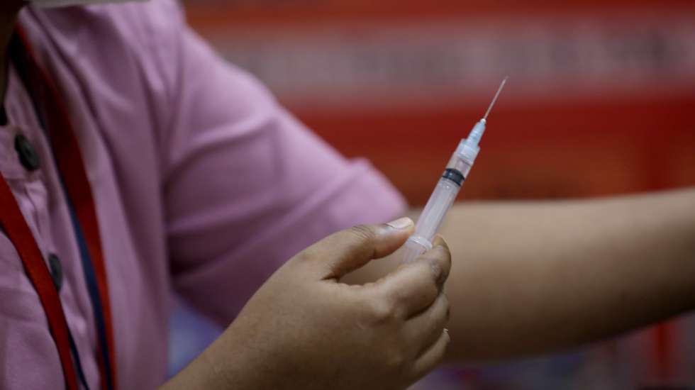 epa09282076 A health worker injects a COVID-19 vaccine shot during a vaccination drive at a shopping mall in Kolkata, India, 18 June 2021. Medica Superspecialty Hospital and Hindustan Club jointly start the vaccination drive.  EPA/PIYAL ADHIKARY