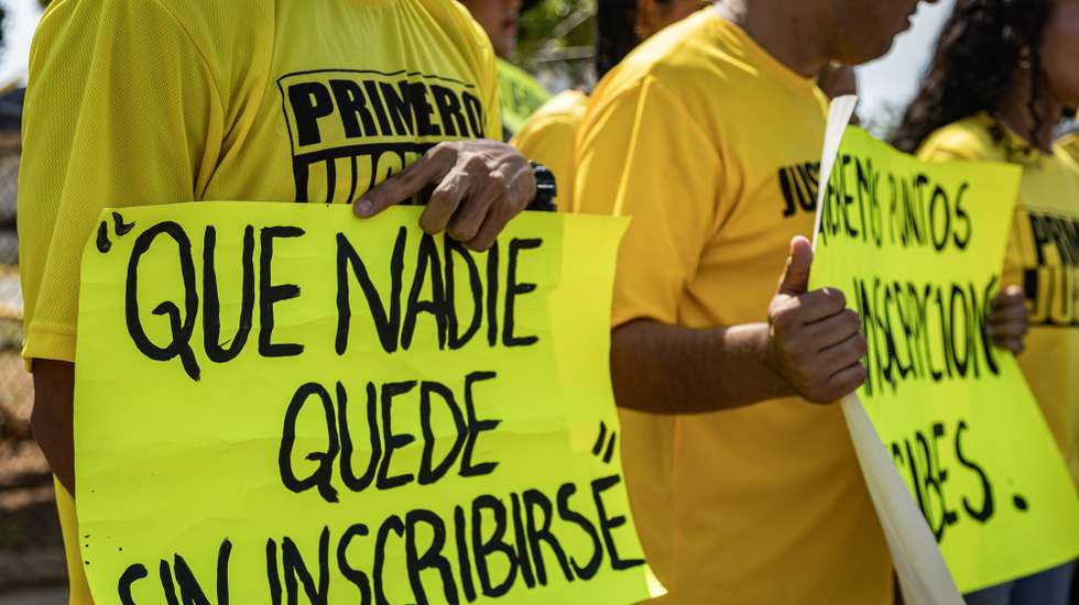 epa12936864 Young members of the opposition party Primero Justicia (PJ) hold signs during a protest outside the offices of the National Electoral Council (CNE) in Maracaibo, Venezuela, 06 May 2026. The youth wing of the PJ party demanded that Venezuela’s CNE open voter registration in the South American country in anticipation of a possible call for elections, four months after Nicolas Maduro’s capture by the United States.  EPA/Henry Chirinos