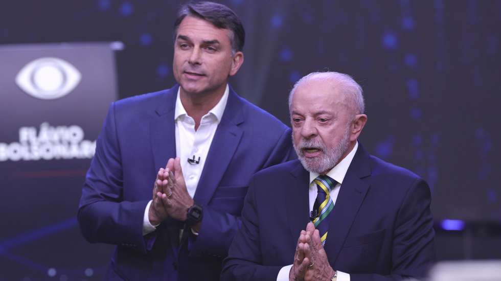 epa13314629 The President of Brazil and candidate for reelection, Luiz Inacio Lula da Silva (R), and opposition candidate Flavio Bolsonaro take part in the first presidential debate at the Rede Bandeirantes headquarters in Sao Paulo, Brazil, 18 October 2026. Lula and Bolsonaro shared their concerns over the country's security and presented their proposals during the first televised electoral debate, one week ahead of the presidential election runoff.  EPA/SEBASTIAO MOREIRA