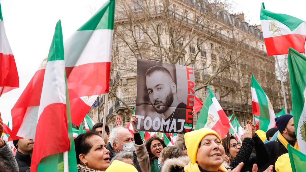 epa10463068 A woman holds a portrait of Iranian hip hop artist Toomaj Salehi, one of the main voices of the Iranian revolution, during a demonstration on the 44th anniversary of the Iranian revolution against Shahh Reza Pahlavi, in Paris, France, 12 February 2023. The protesters rejected the Shah's dictatorshipin the then Imperial State of Iran from 16 September 1941 until he was overthrown in the Iranian Revolution on 11 February 1979, and the following mullahs' theocracy and called for a democratic and secular government in Iran.  EPA/TERESA SUAREZ