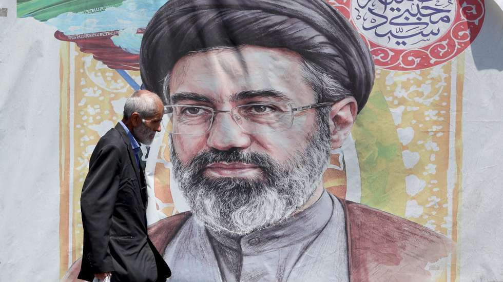 epa13046115 An Iranian man walks past a poster of Iranian supreme leader Ayatollah Mojtaba Khamenei in a street in Tehran, Iran, 18 June 2026. Iran and the US signed a peace agreement to end the war between the two countries.  EPA/ABEDIN TAHERKENAREH RESTRICTIONS: NO Access Israel Media/Persian Language TV Stations Outside Iran/Strictly No Access BBC Persian/VOA Persian/Manoto TV/Iran International TV. (As mandated by Iran's Directorate General for Foreign Media) --
