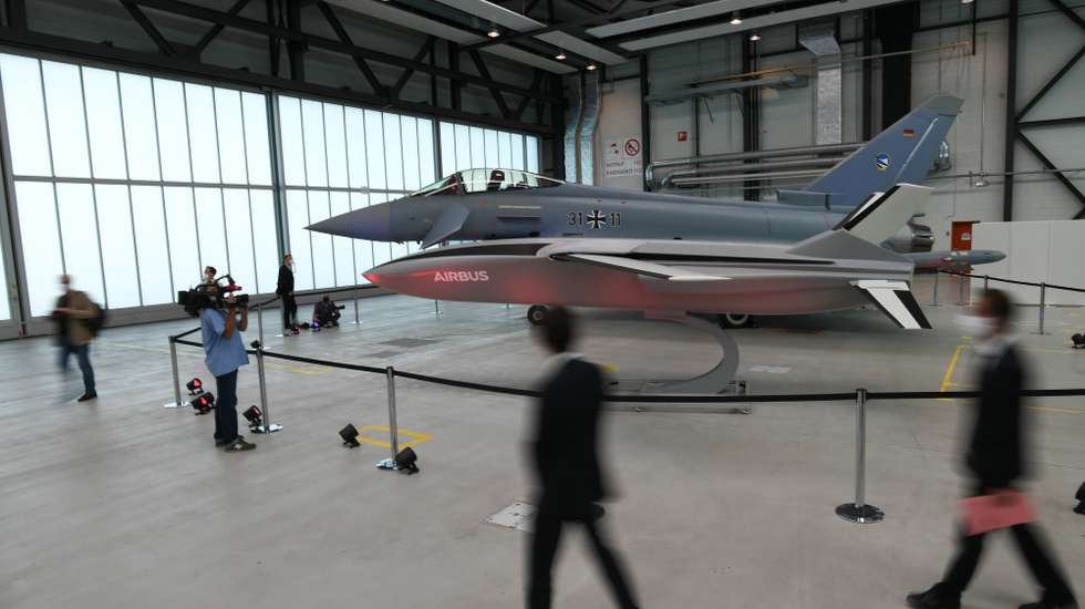 epa08675761 A model of a remote carrier drone and a Eurofighter jet are displayed in a hangar during a visit of German and French defense officials to the Airbus military aviation center in Manching, Germany, 17 September 2020. German Defense Minister Annegret Kramp-Karrenbauer and French Defense Minister Florence Parly are in Manching to be informed among others of the Future Combat Air System (FCAS), the next-generation fighter jet program, that is developed together by Germany, France and Spain.  EPA/PHILIPP GUELLAND