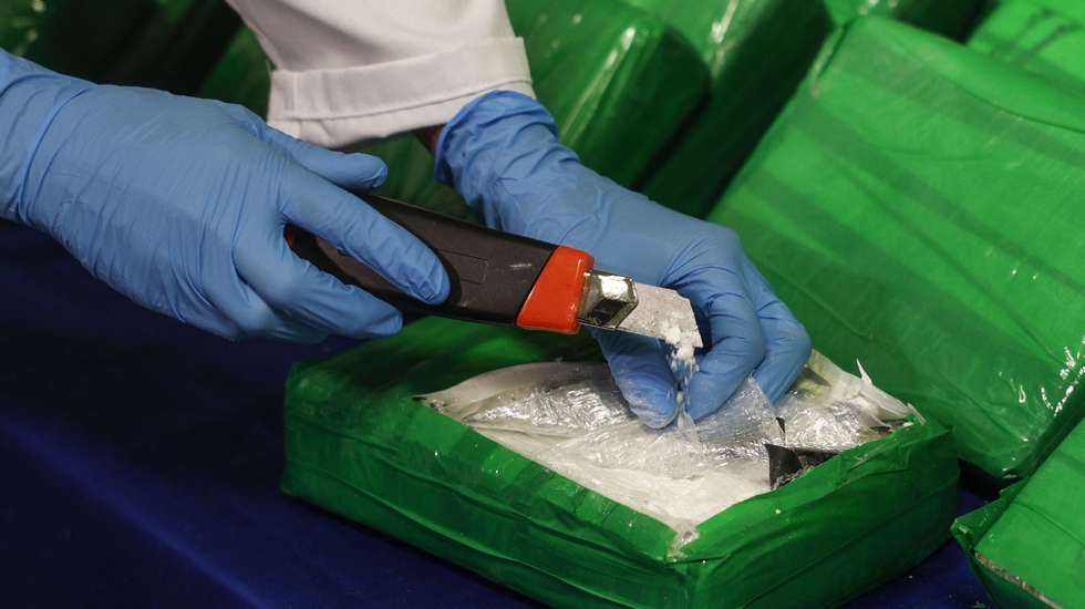 Uma agente da Polícia Judiciária (PJ), mostra o interior de embalagens de cocaína escondidas em caixas de bananas, após a sua apreensão na operação "Acácias", em Lisboa, 30 de dezembro de 2024. A operação foi realizada nos últimos dias pela Unidade Nacional de Combate ao Tráfico de Estupefacientes, de localização e apreensão de cerca de três toneladas e meia de cocaína chegadas a território nacional por um porto marítimo. ANTÓNIO PEDRO SANTOS/LUSA
