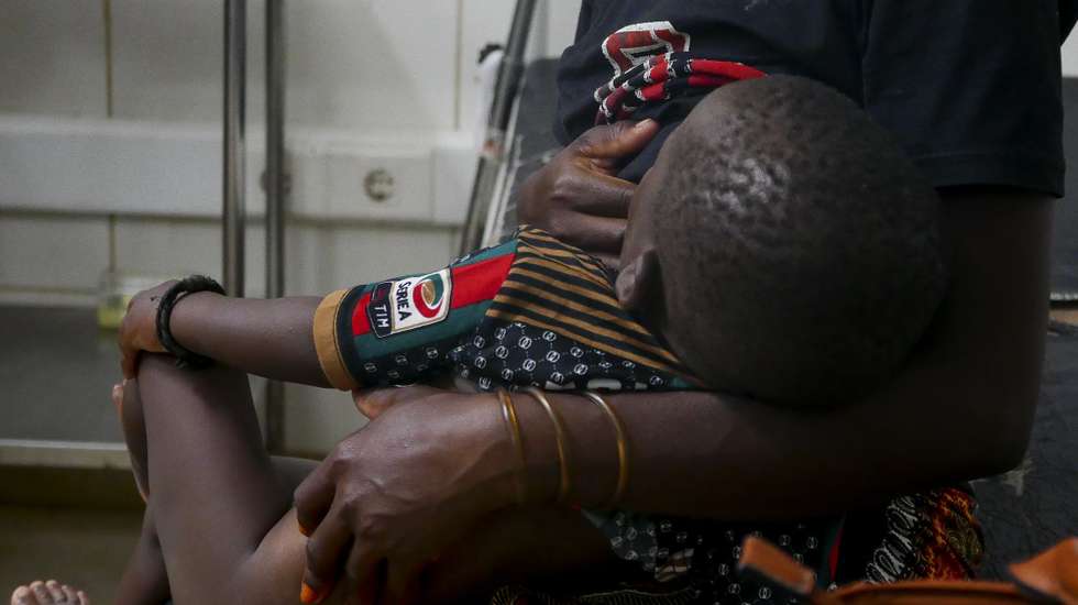 Uma mulher dá de mamar ao filho de 01 ano que foi alvejado numa perna enquanto a mãe o levava ao colo da fuga de Palma, na quarta-feira, Pemba, em Moçambique, 29 de março de 2021. Calmo e nutrido, tem o ferimento tratado, mas vai voltar a ser observado no banco de socorro do Hospital de Pemba para que de uma vez por todas se extraia a bala. (ACOMPANHA TEXTO) LUÍS FONSECA/LUSA