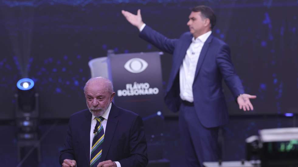 epa13314646 The President of Brazil and candidate for reelection, Luiz Inacio Lula da Silva (L), and opposition candidate Flavio Bolsonaro speak during the first presidential debate at the Rede Bandeirantes headquarters in Sao Paulo, Brazil, 18 October 2026. Lula attacked Bolsonaro by linking him to Argentine President Javier Milei and US President Donald Trump; meanwhile, the opposition candidate responded by connecting his opponent to Nicaraguan Head of State Daniel Ortega and deposed Venezuelan president Nicolas Maduro.  EPA/SEBASTIAO MOREIRA