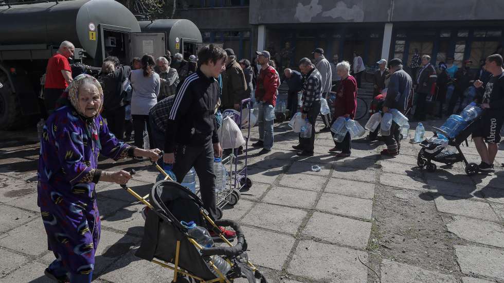 epa09917338 A picture taken during a visit to Luhansk organized by the Russian military shows local people stand in line to collect drinking water from mobile tanks provided by new city administration of Mariupol, Ukraine, 29 April 2022. According to Eduard Basurin, spokesman of the self-proclaimed Donetsk People's Republic (DPR): 'after two months of continued hostility in the city, the main battles in Mariupol are over'. On 24 February Russian troops had entered Ukrainian territory in what the Russian president declared a 'special military operation', resulting in fighting and destruction in the country, a huge flow of refugees, and multiple sanctions against Russia.  EPA/SERGEI ILNITSKY