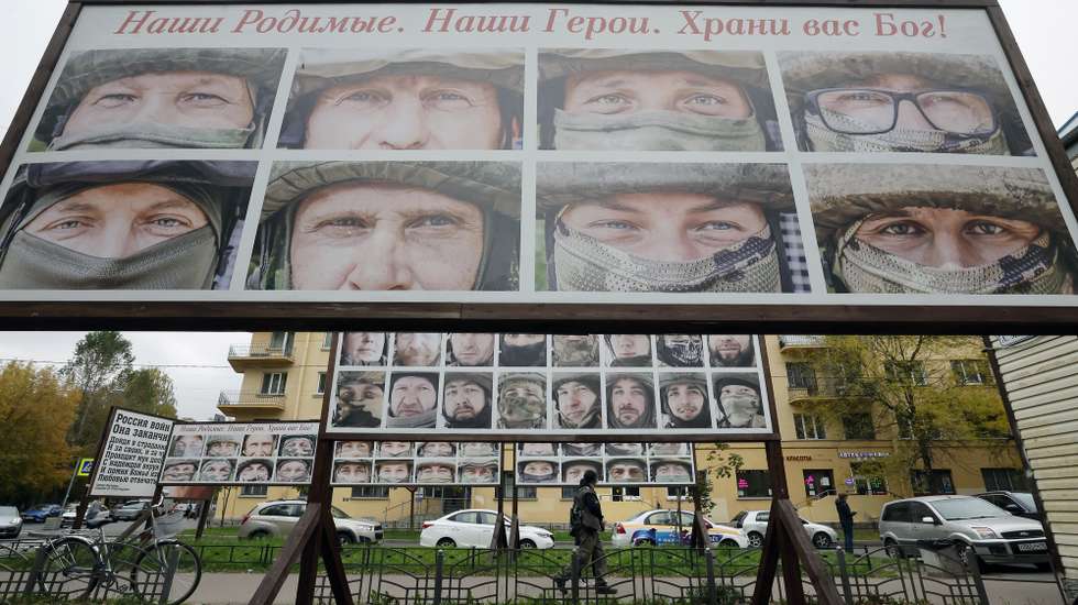 epa12444849 People walk past portraits of Russian soldiers fighting during the Special Military Operation in Ukraine, near the office of a charity fund that collects donations for Russian soldiers, in St. Petersburg, Russia, 10 October 2025.  EPA/ANATOLY MALTSEV
