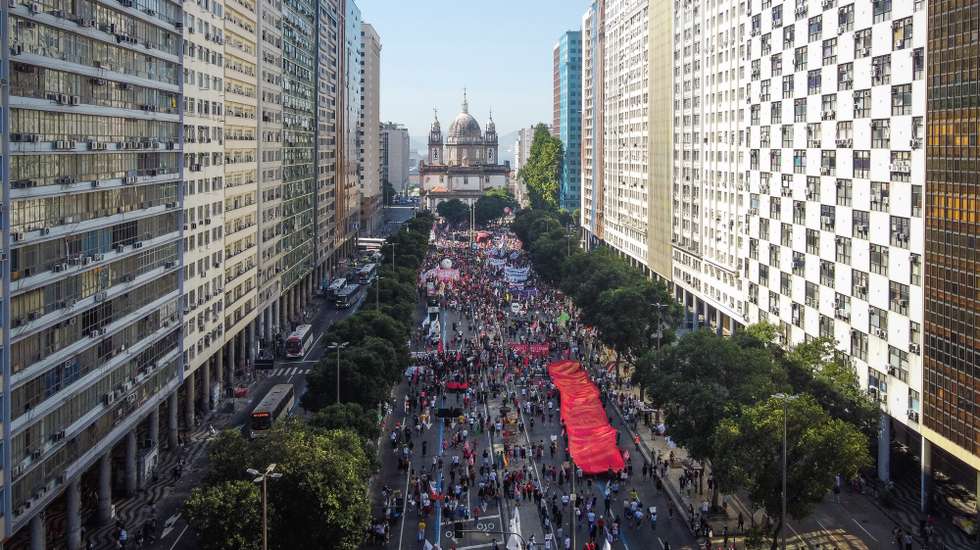 epa09320679 An aerial picture taken with a drone showing people protesting against the President of Brazil, Jair Bolsonaro, in Rio de Janeiro, Brazil, 03 July 2021. The Brazilian Attorney General's Office will have a period of 90 days to investigate the possible irregularities that President Jair Bolsonaro may have incurred in negotiations for vaccines against covid-19, the Supreme Court reported on 03 July. The Church of Nossa Senhora da Candelaria is seen in the background.  EPA/Andre Coelho