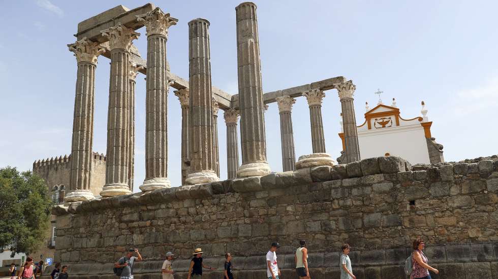 Turistas procuram a sombra ao visitar o Templo Romano, quando em Évora os termómetros ao final da manhã chegam aos 40 graus, 13 de julho de 2022. Devido a uma onda de calor em Portugal continental, que dura há vários dias, são esperadas temperaturas acima dos 45 graus em vários pontos do Alentejo e Ribatejo. NUNO VEIGA/LUSA