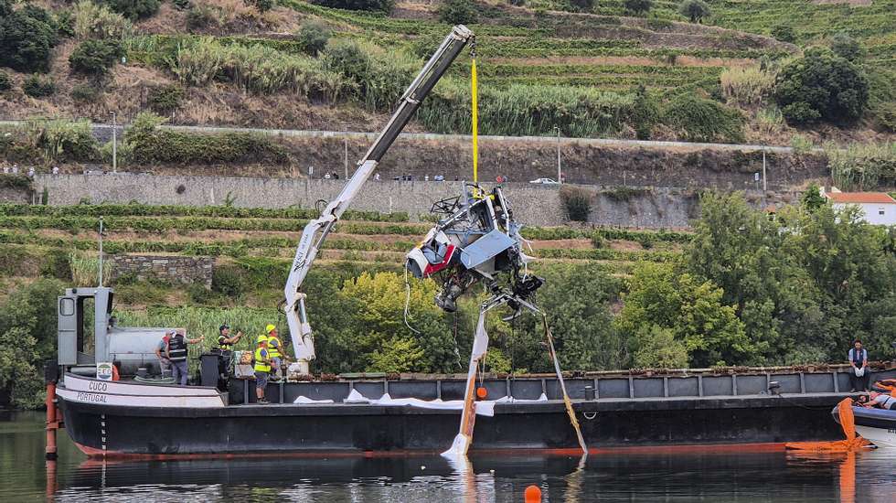 epa11575638 A vessel with a crane removes parts of a helicopter that crashed on 30 August in the River Douro, near the town of Samodaes in Lamego, carrying six passengers, namely a pilot and a team of five soldiers from the Emergency Protection and Relief Unit (UEPS) returning from fighting a fire in the municipality of Baiao, in Lamego, Portugal, 31 August 2024. The pilot of the aircraft was rescued alive, with only minor injuries. So far, the bodies of four GNR soldiers have been located, while another man, aged between 29 and 45, is still missing, according to the officials.  EPA/PAULA LIMA IMAGE TAKEN WITH A SMARTPHONE