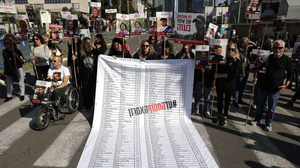 epa11810891 Families and supporters of hostages held by Hamas in Gaza display a banner listing the names of the hostages during a protest calling for a ceasefire and for their release outside the Kirya military base in Tel Aviv, Israel, 07 January 2025. According to the Israeli army, around 100 hostages remain in captivity in the Gaza Strip,  including bodies of 33 confirmed dead.  EPA/ABIR SULTAN