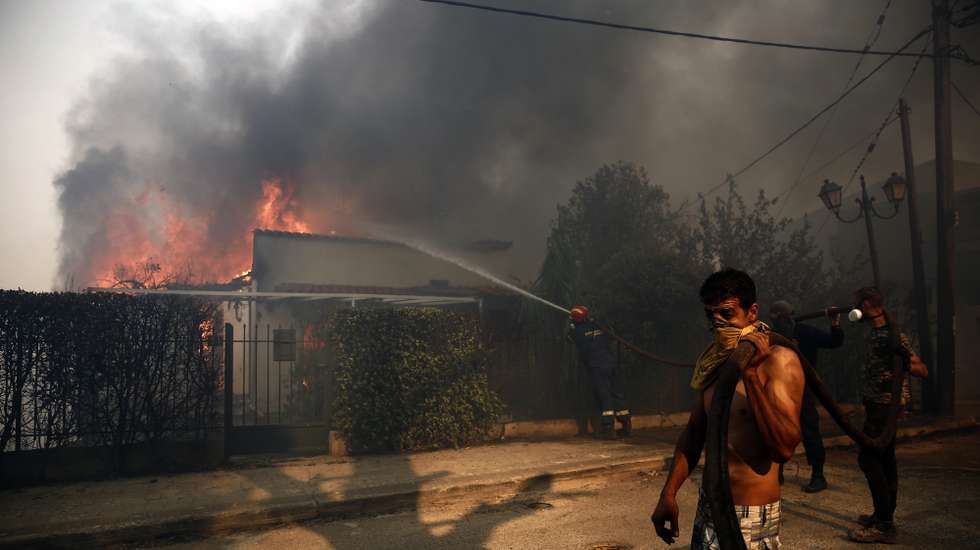 epa12264407 Firefighters and volunteers battle to put out a fire burning houses in the residential area of Kryoneri, in the suburbs of Athens, Greece, 26 July 2025. Firefighting forces are battling the wildfire that broke out in Kryoneri, Attica. According to the Fire Service, the fire is considered difficult as it is spreading through a mixed area of forest and residential zones. There are reports of damage to homes, and some have been engulfed in flames.  EPA/YANNIS KOLESIDIS