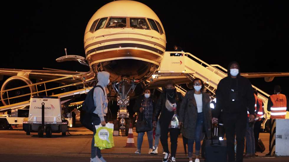 Passageiros saiem do avião da TACV - Transportes Aéreos de Cabo Verde S.A., no dia da  retoma dos voos 19 meses depois, no aeroporto internacional da Praia, Cidade da Praia, Cabo Verde, 27 de dezembro de 2021. ELTON MONTEIRO/ LUSA